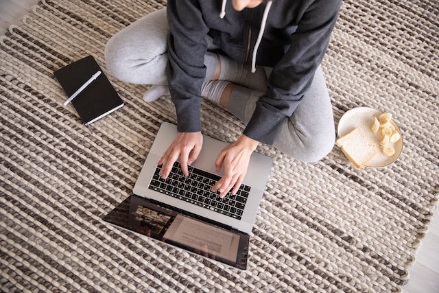 person working on a laptop on the floor