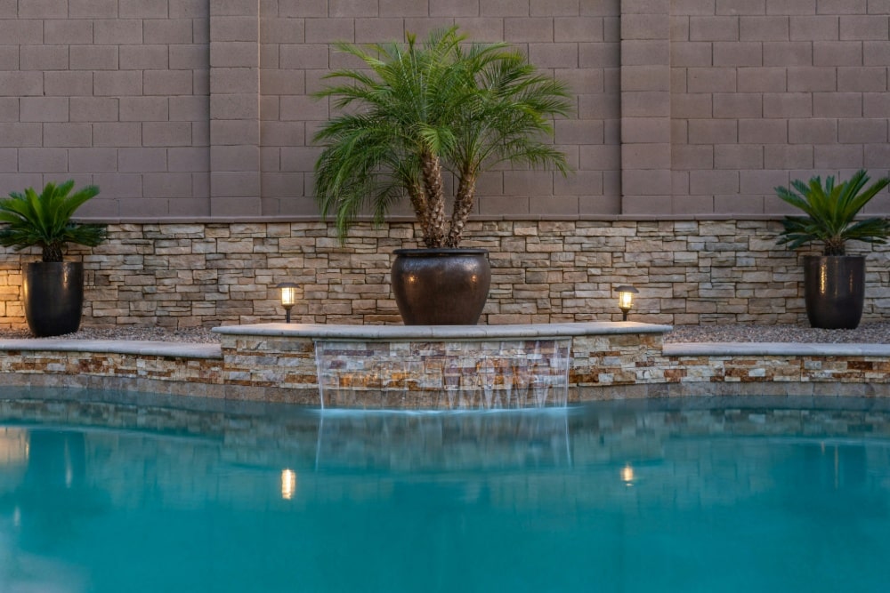 A beautiful pool with a green plant and lighting 