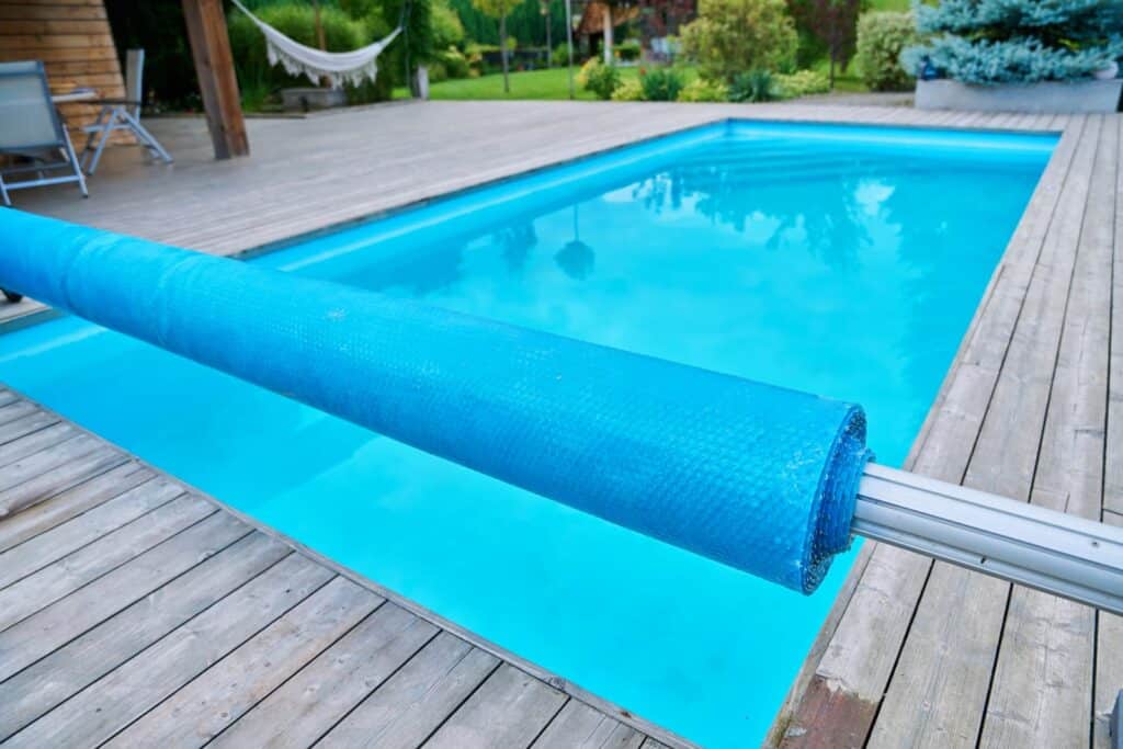 Outdoor swimming pool installed in the backyard with pool cover