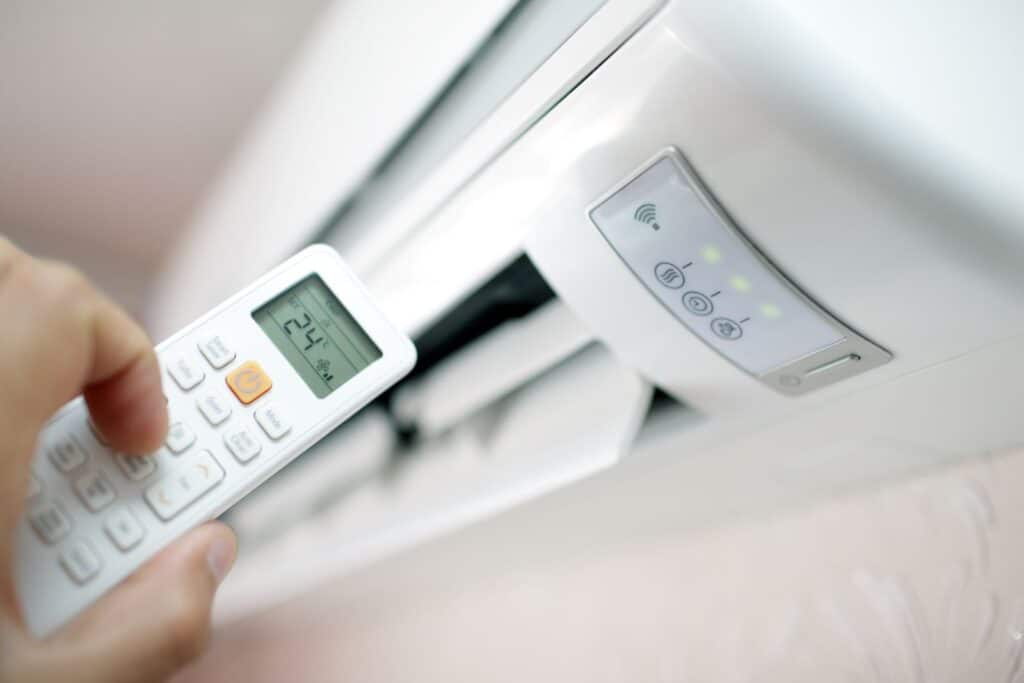 air conditioning heat pump with person holding remote