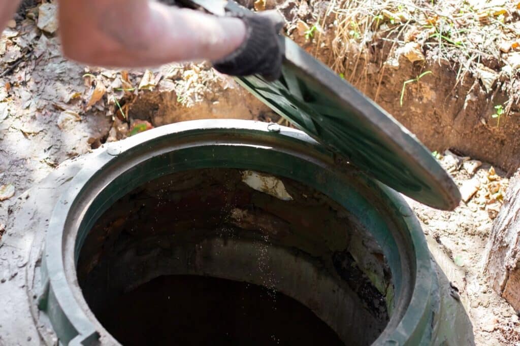 man opening septic tank hatch for inspection
